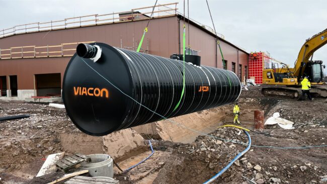 ViaCon large black watertank being hoisted by crane at Skövde construction site for stormwater management solutions.