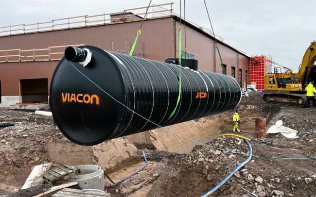 ViaCon large black watertank being hoisted by crane at Skövde construction site for stormwater management solutions.